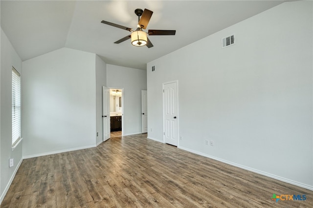 unfurnished bedroom featuring wood-type flooring, ensuite bath, vaulted ceiling, and ceiling fan