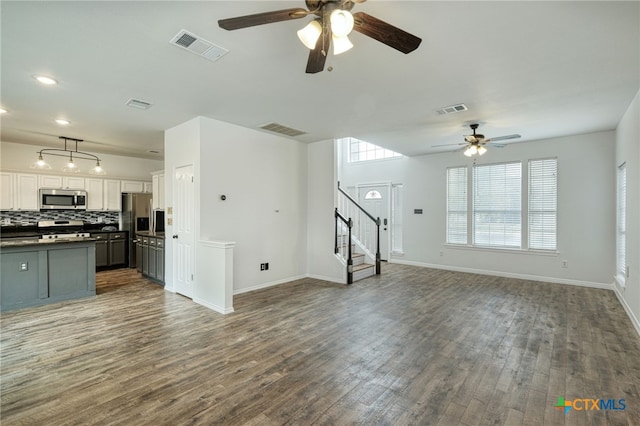 unfurnished living room featuring wood-type flooring and ceiling fan