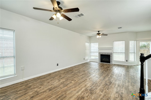 unfurnished living room with hardwood / wood-style floors, ceiling fan, and a tile fireplace