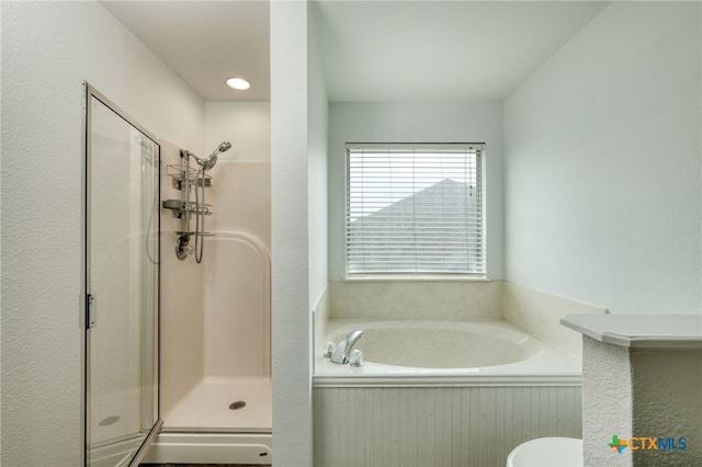 bathroom featuring separate shower and tub and toilet