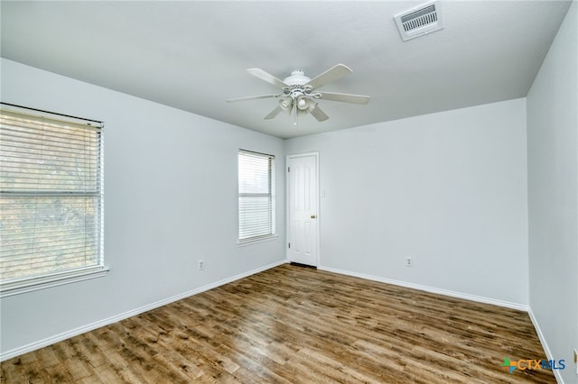 empty room with hardwood / wood-style floors and ceiling fan