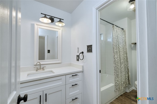 full bathroom with shower / bath combo with shower curtain, vanity, wood-type flooring, and toilet