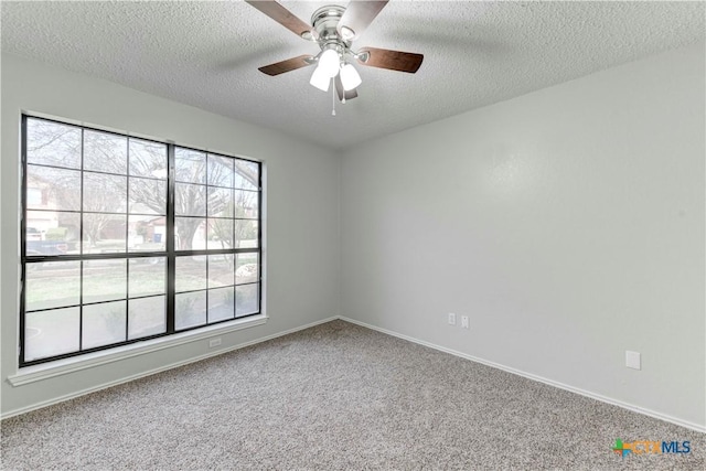 empty room featuring baseboards, a textured ceiling, a ceiling fan, and carpet floors