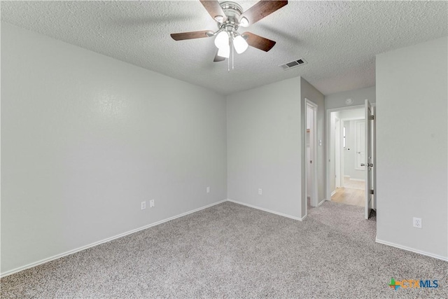 unfurnished bedroom featuring visible vents, carpet flooring, a textured ceiling, and baseboards