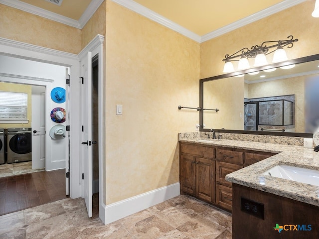 bathroom with independent washer and dryer, vanity, ornamental molding, and wood-type flooring