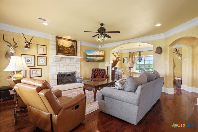 living room featuring dark hardwood / wood-style floors, a stone fireplace, and ornamental molding