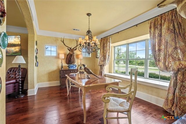 dining area with dark hardwood / wood-style flooring, ornamental molding, and an inviting chandelier