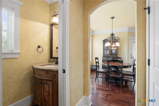 bathroom with a chandelier, wood-type flooring, plenty of natural light, and crown molding