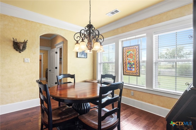 dining room featuring dark hardwood / wood-style floors, an inviting chandelier, and ornamental molding