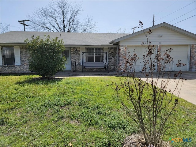 single story home with concrete driveway, a front lawn, an attached garage, and brick siding