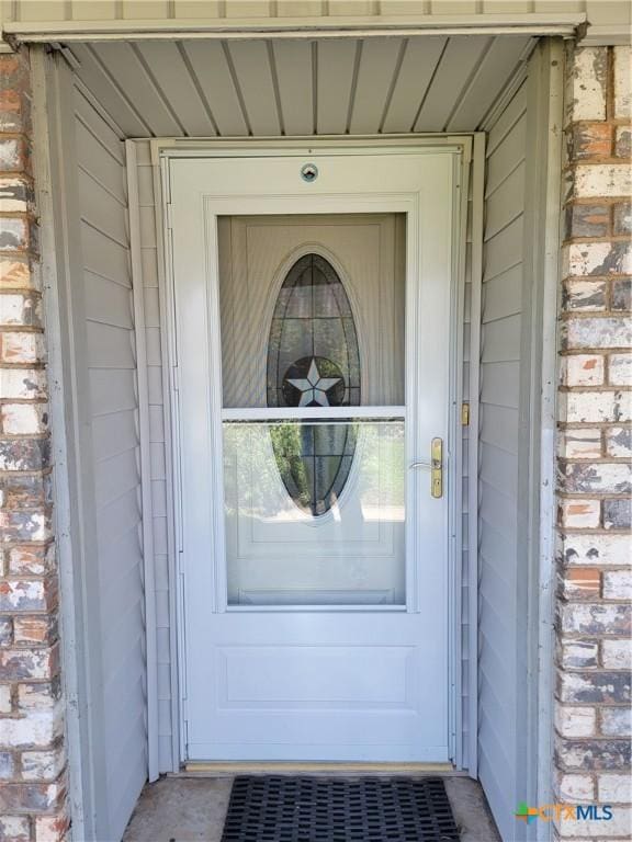 entrance to property featuring brick siding