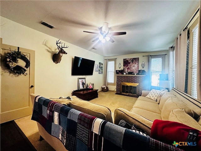 living room with light colored carpet, ceiling fan, and a brick fireplace