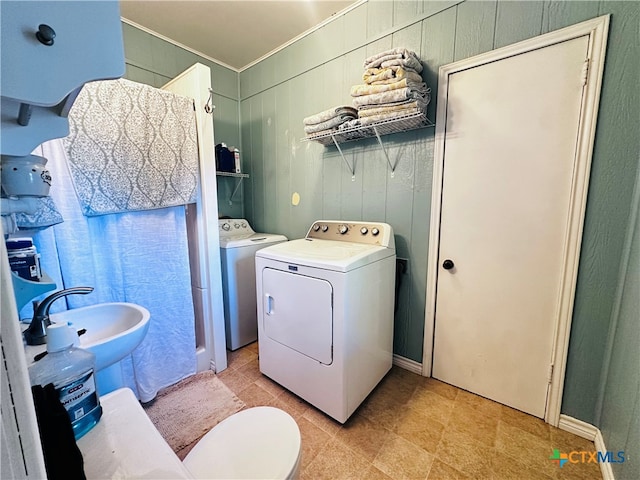 clothes washing area featuring washer and clothes dryer and sink