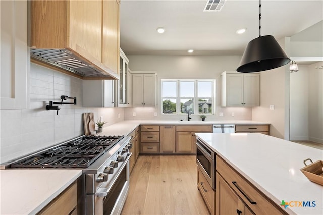 227 Glenview Cir, Belton, TX 76513 - kitchen with stainless steel appliances, a sink, light wood finished floors, tasteful backsplash, and light countertops