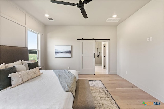 227 Glenview Cir, Belton, TX 76513 - bedroom with light wood finished floors, a barn door, baseboards, ceiling fan, and recessed lighting