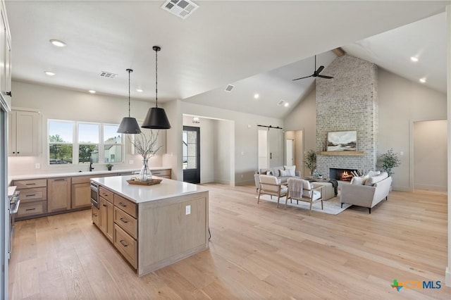 227 Glenview Cir, Belton, TX 76513 - kitchen featuring a barn door, open floor plan, light wood-style flooring, a ceiling fan, and light countertops