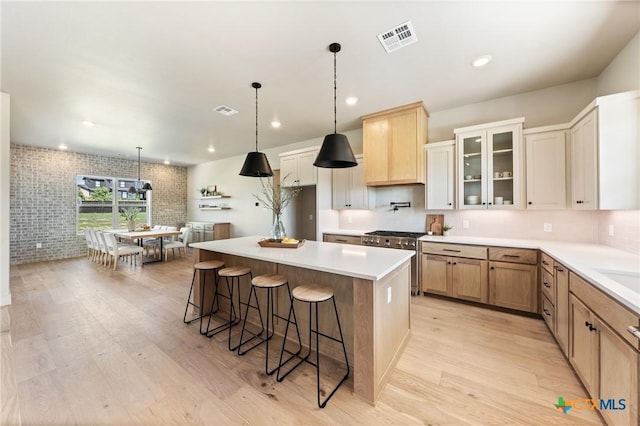 227 Glenview Cir, Belton, TX 76513 - kitchen with gas range, light wood-style floors, a kitchen bar, a center island, and hanging light fixtures