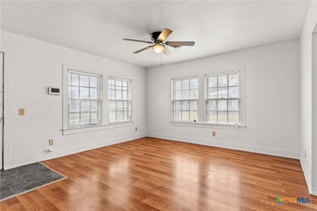 unfurnished room with ceiling fan, baseboards, and wood finished floors