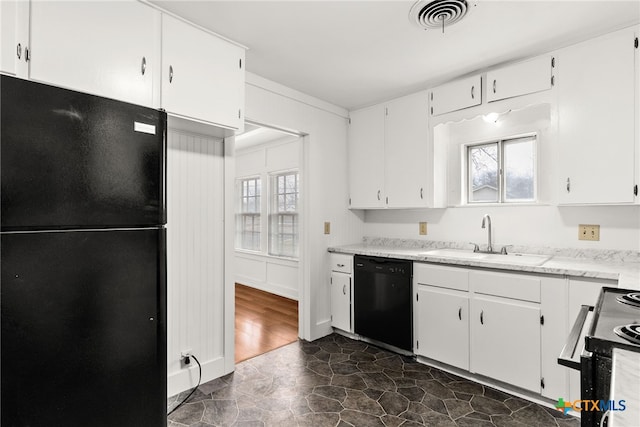 kitchen featuring visible vents, white cabinetry, a sink, light stone countertops, and black appliances