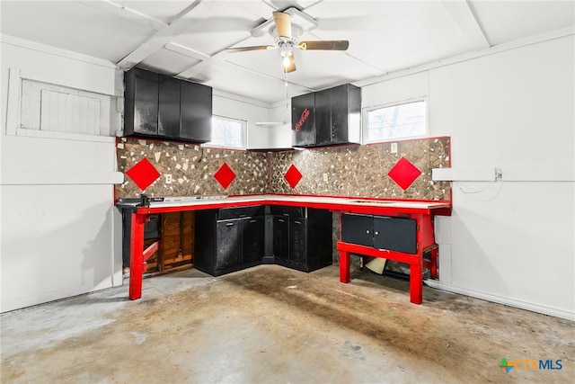 kitchen with dark cabinetry, backsplash, a ceiling fan, and unfinished concrete floors