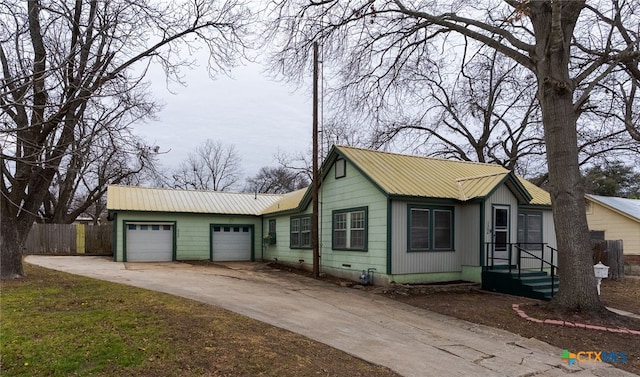 ranch-style house with concrete driveway, metal roof, an attached garage, crawl space, and fence