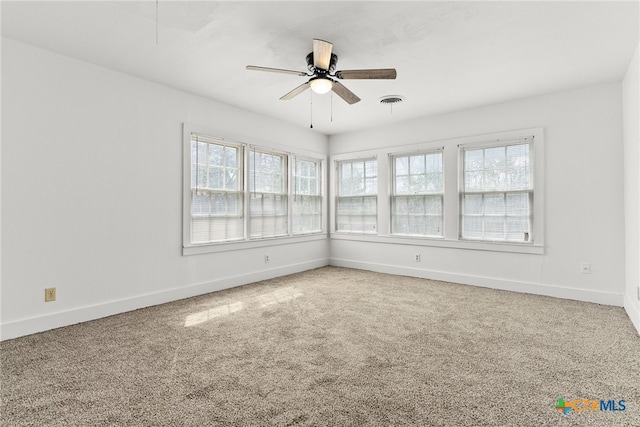 unfurnished room featuring visible vents, carpet floors, a ceiling fan, and baseboards