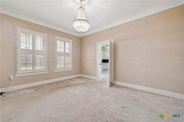 carpeted empty room featuring baseboards, ornamental molding, and a notable chandelier