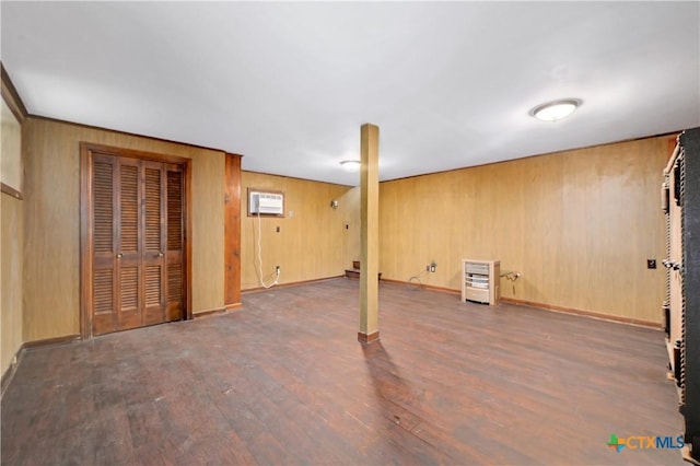 finished below grade area featuring wooden walls, baseboards, wood finished floors, and a wall mounted AC