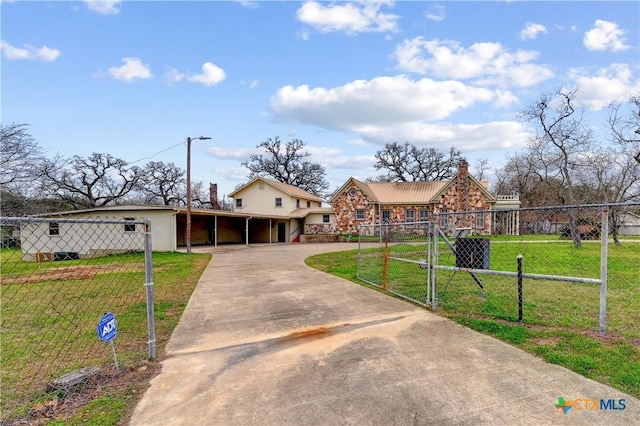 view of front of home featuring an attached carport, driveway, a front lawn, and fence