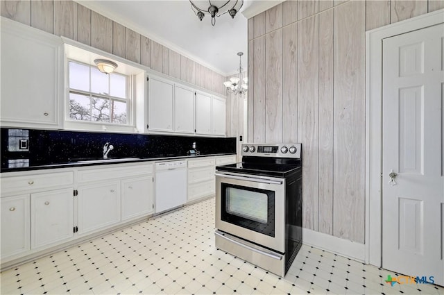 kitchen with white dishwasher, a sink, stainless steel electric range oven, light floors, and dark countertops