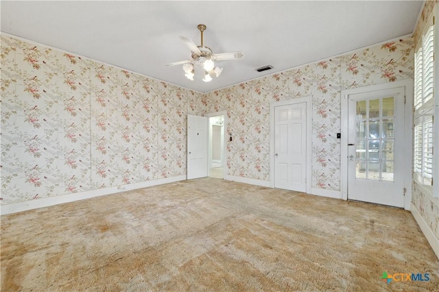 carpeted empty room with baseboards, a wealth of natural light, and wallpapered walls