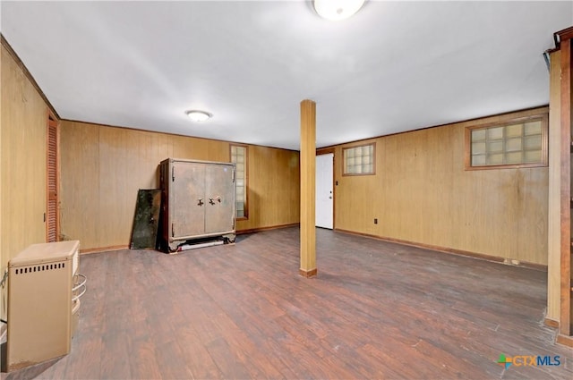 below grade area featuring baseboards, wood finished floors, and wooden walls