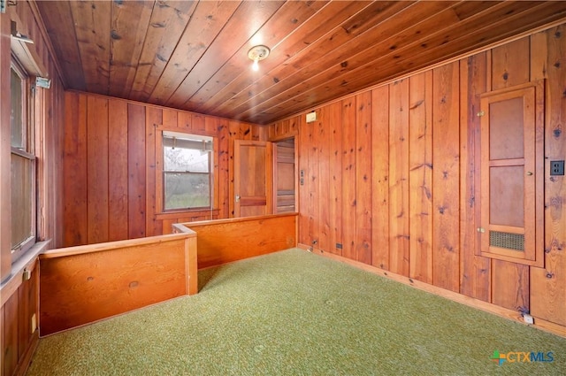 carpeted empty room with wood walls and wood ceiling