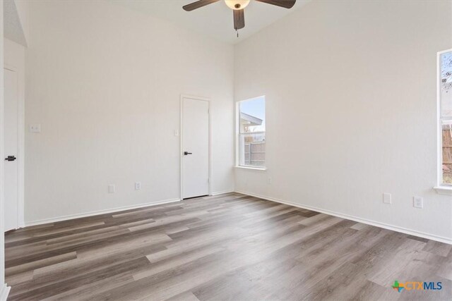 unfurnished room featuring ceiling fan, hardwood / wood-style floors, and high vaulted ceiling