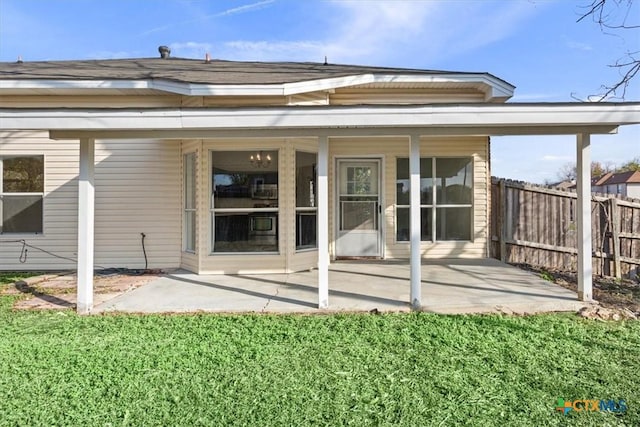 back of house featuring a lawn and a patio