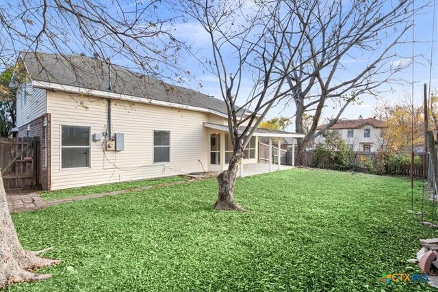 rear view of property featuring a lawn and a patio