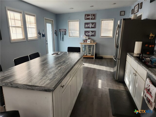 kitchen with white cabinets, dishwashing machine, dark wood-type flooring, and a center island