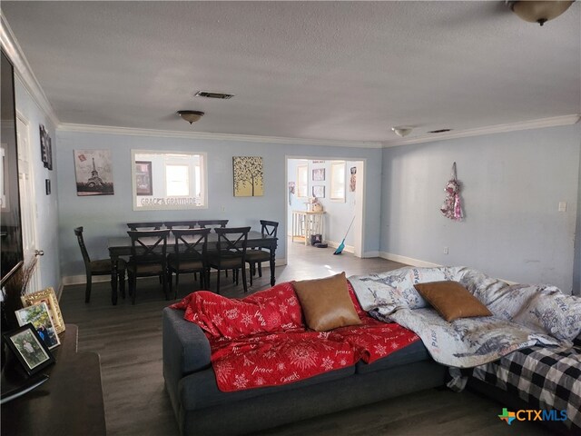 living room with a textured ceiling, hardwood / wood-style flooring, and crown molding