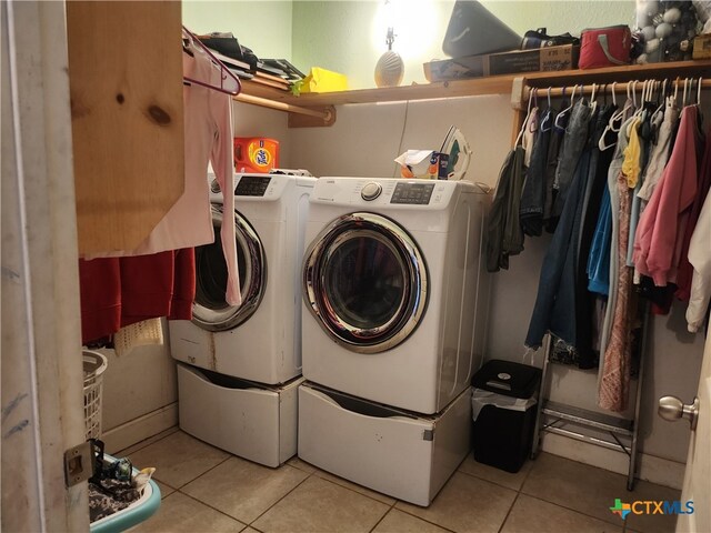 laundry room with light tile patterned flooring and washing machine and clothes dryer