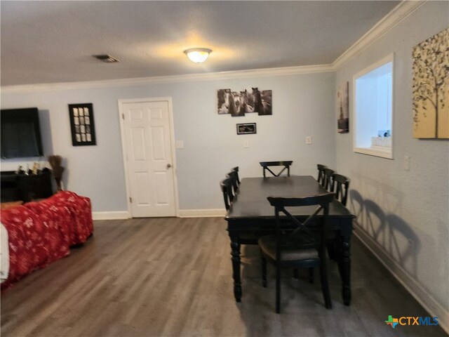 dining area with wood-type flooring, a textured ceiling, and crown molding