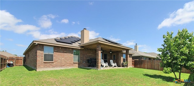 6704 Deorsam Loop, Killeen, TX 76542 - rear view of property featuring a ceiling fan, roof mounted solar panels, a patio, brick siding, and a chimney