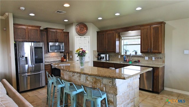 6704 Deorsam Loop, Killeen, TX 76542 - kitchen featuring appliances with stainless steel finishes, recessed lighting, a sink, a center island, and light stone counters