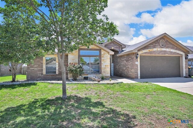 6704 Deorsam Loop, Killeen, TX 76542 - single story home featuring an attached garage, brick siding, concrete driveway, a front lawn, and stone siding