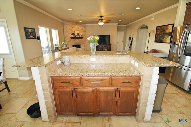 6704 Deorsam Loop, Killeen, TX 76542 - kitchen with stainless steel fridge with ice dispenser, crown molding, ceiling fan, arched walkways, and light stone countertops