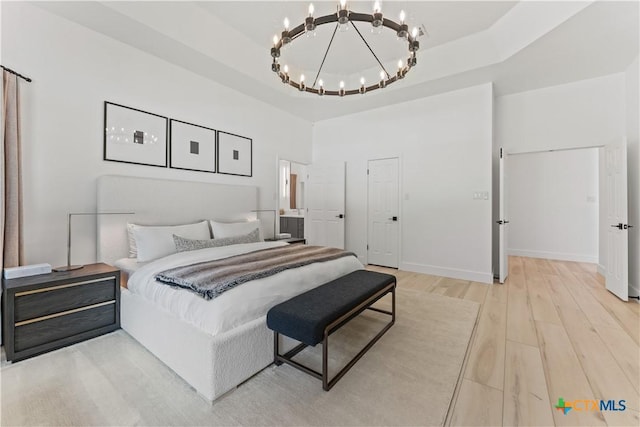 bedroom featuring light wood-type flooring and an inviting chandelier