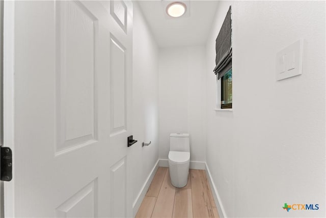 bathroom featuring wood-type flooring and toilet