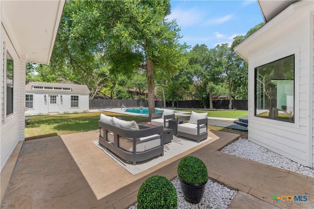 view of patio featuring an outdoor structure, a fenced in pool, and an outdoor hangout area