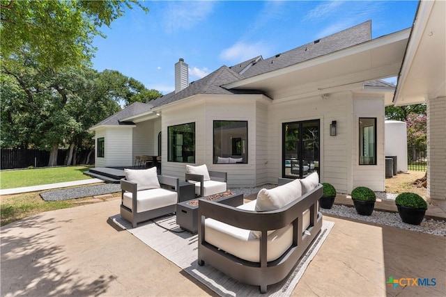 exterior space featuring cooling unit and an outdoor living space with a fire pit