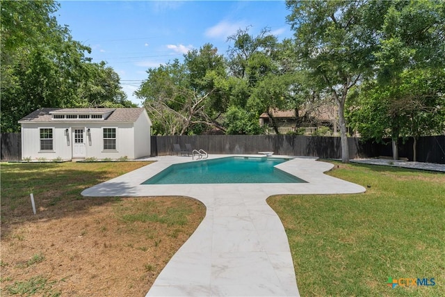 view of pool featuring a yard, a diving board, an outbuilding, and a patio