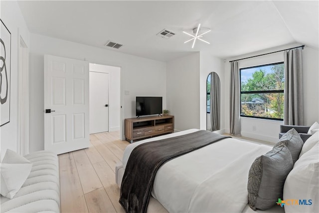 bedroom featuring lofted ceiling and light wood-type flooring